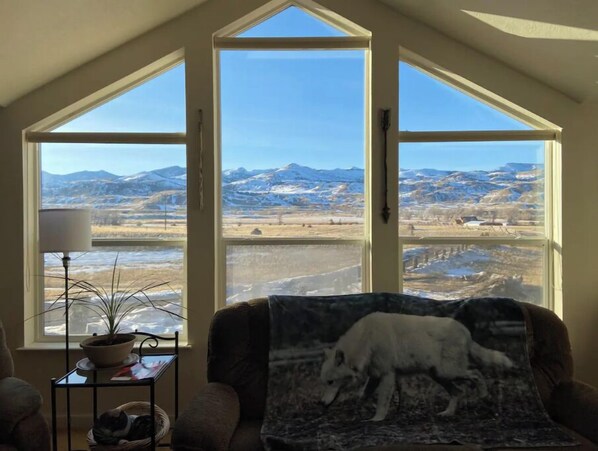 Relax in a room with a high ceiling and panoramic mountain views from the large window.
