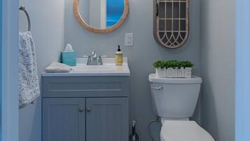 Een badkamer met een wastafel, toilet, spiegel en raam.