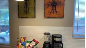 Un plan de travail de cuisine avec une machine à café, un mixeur et divers aliments.
