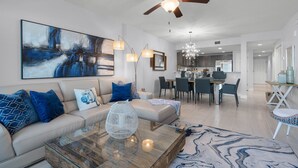 A modern living room with a sofa, coffee table, and artwork. - Professionally Designed & Decorated Luxury Oceanfront Paradise (Daytona Beach)
