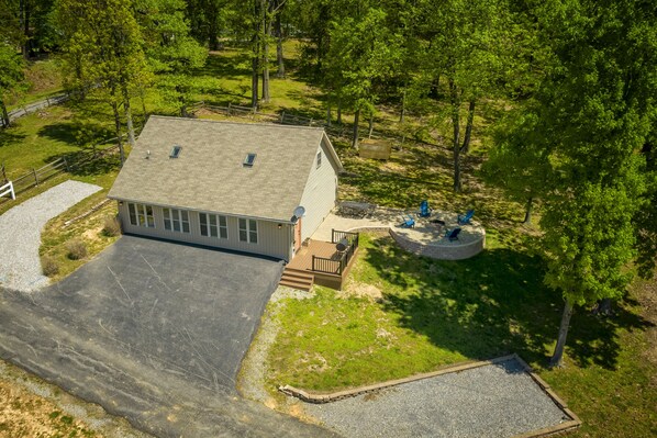 A two-story house with a large driveway, a covered patio, and a fenced yard.