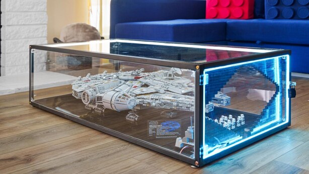 A Star Wars Millennium Falcon model inside a glass display case. - LEGO Dream! 🧱🌊🕹️⛳🎥 Heated Pool, Theater, Arcade, & more! (Garden Grove)