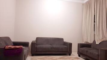 Suite Deluxe, 2 habitaciones | Zona de estar | Televisión de pantalla plana de 41 pulgadas con canales digitales