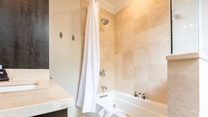 Ein modernes Badezimmer mit Badewanne, Dusche und Waschtisch mit Handtuchhalter.