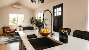 Una cocina moderna con una isla central, un grifo negro y un cuenco de limones.
