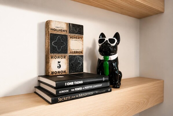 A shelf with books, a decorative block, and a black cat figurine. - Beautiful and Cozy Home in Snoqualmie, Walk to Restaurants, The Falls, & Shops (Snoqualmie)