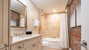 Un baño con lavamanos, espejo y cabina de ducha.