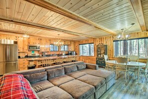 A wooden cabin interior with a kitchen, dining area, and a large sofa. - Furnished Patio & Fire Pit: Pinetop Cabin! (Pinetop)