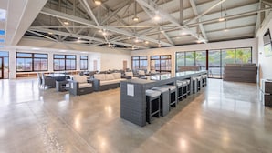 A spacious indoor area with high ceilings, large windows, and a long bar area with seating. - 🌺 Oahu Ocean & Mountain Views • Sleeps 14 • Pool, Spa, Near Beach, AC & BBQ 🌺 (Waianae)