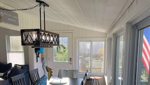 A spacious dining area with a long table, chairs, and a decorative bird sculpture. - Lazy Days: mid-term private waterfront cottage at the lake (Brighton)