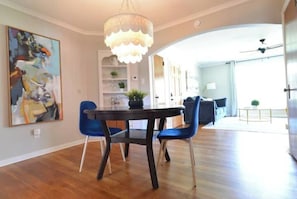 Enjoy meals in this dining area with a large table, comfortable chairs, and a beautiful abstract painting.