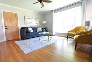 Relax in this inviting living space with a sofa, coffee table, and armchair, offering a view of the outdoors.