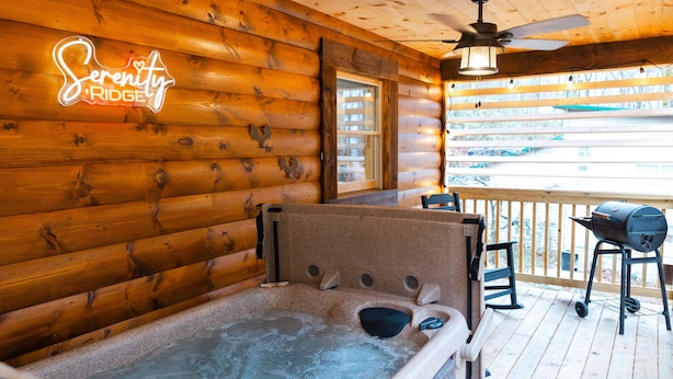 Ein Holzblock-Interieur mit Whirlpool, Deckenventilator und Blick ins Freie.