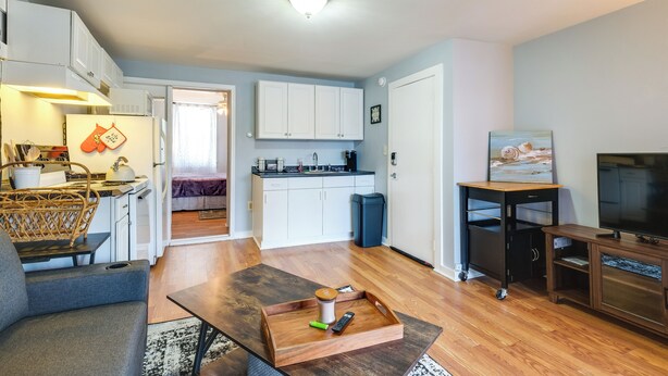 Un espacio habitable compacto con kitchenette, comedor y televisor.