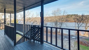 Una terraza techada con vistas a un río y árboles.