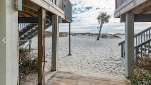 A wooden staircase leading to a beach area with a palm tree and a view of the ocean. - Ocean Reef 701 3 Bedroom Townhouse by RedAwning (Gulf Shores)