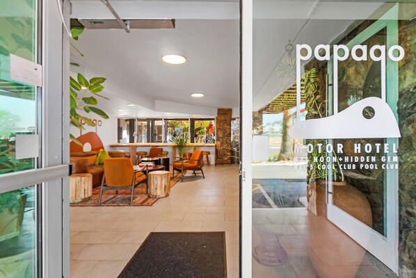 A hotel lobby with a reception area, seating, and a view of the outdoor garden. - Papago Scottsdale by Reside, Trademark Collection by Wyndham (Scottsdale)