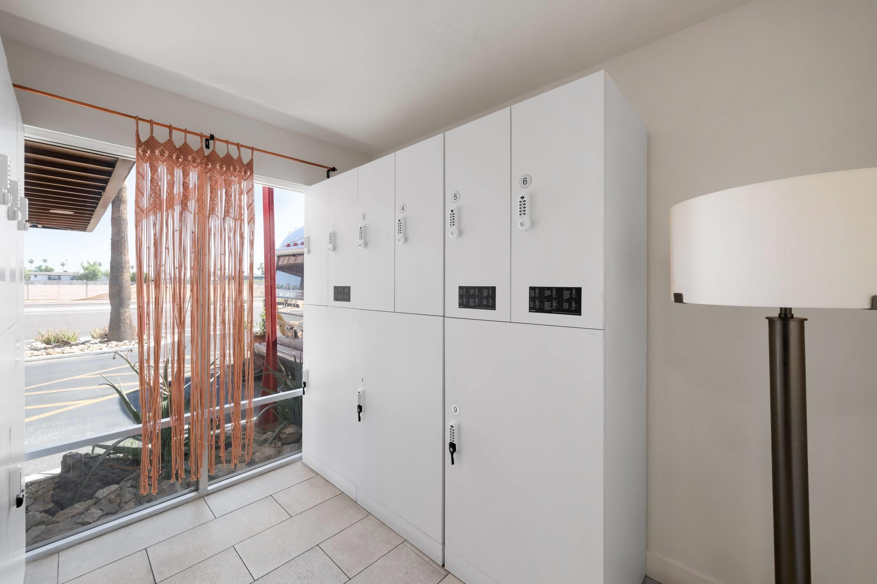 Un interior moderno con un gran ventanal, una cortina decorativa y una lámpara de pie alta.