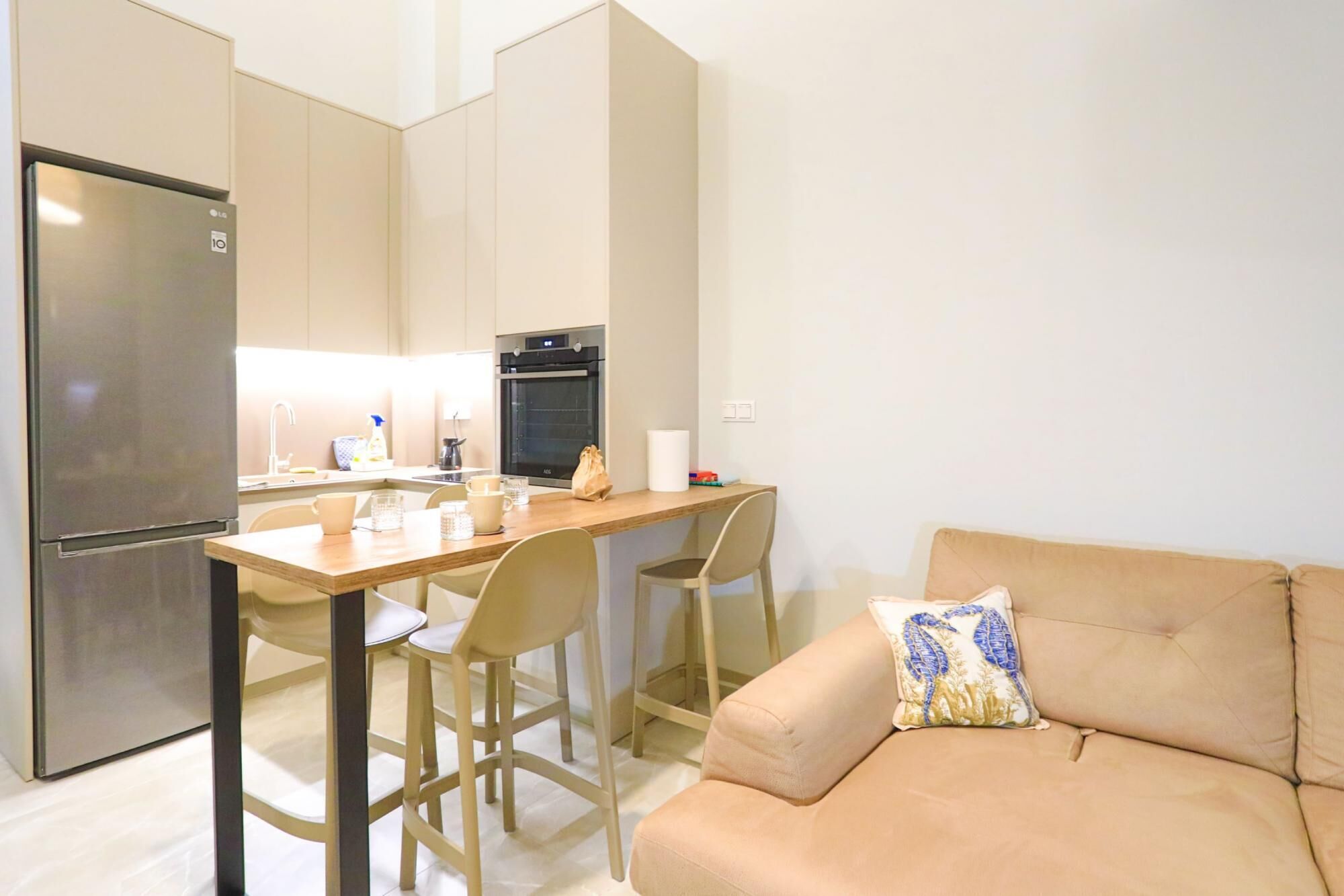 A modern kitchen with a refrigerator, oven, and dining area.
