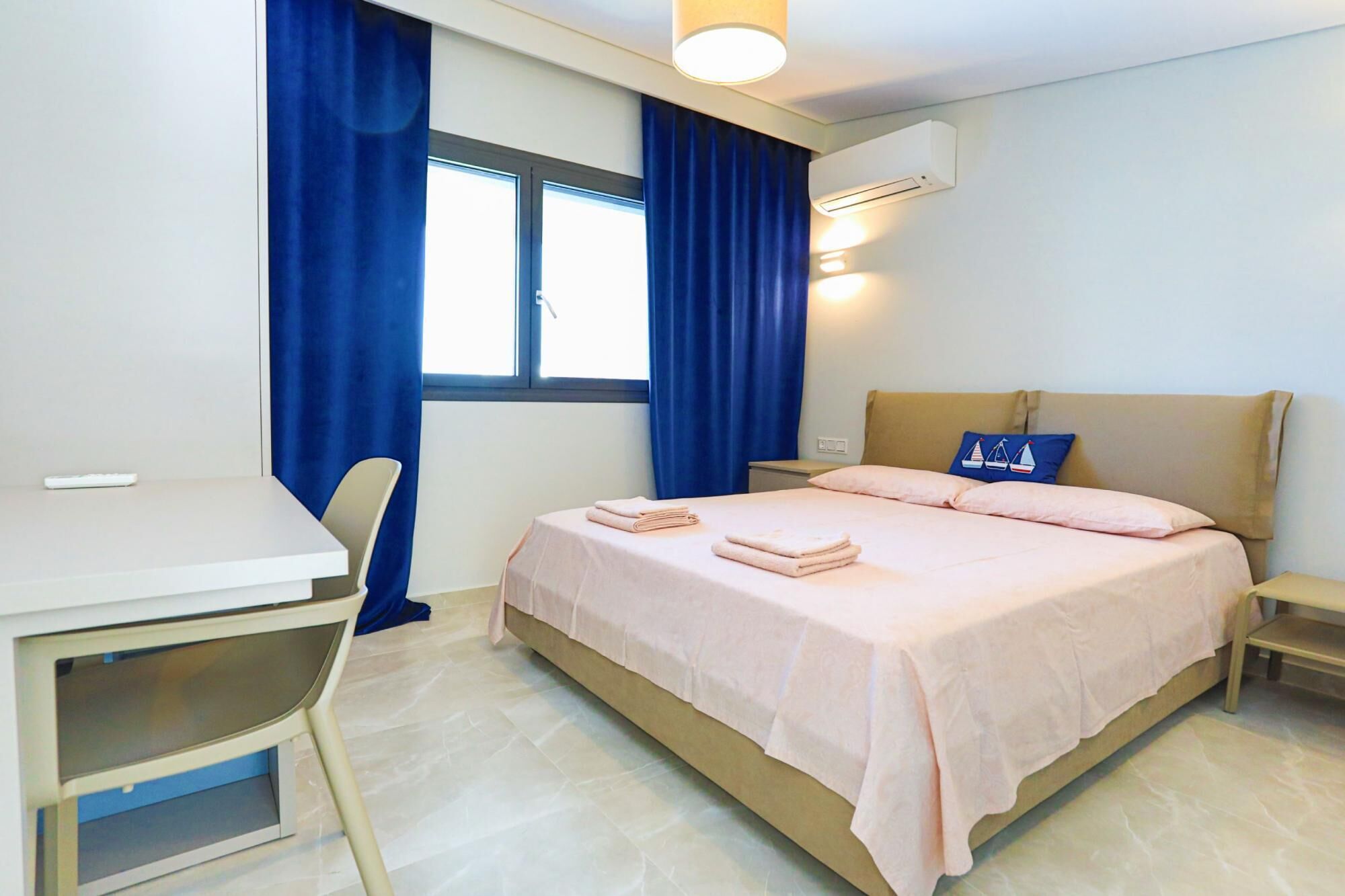 A hotel room with a bed, a desk, and a chair.
