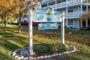 Señal de Harborage Pointe, una comunidad Lake Guardian, con un edificio al fondo.