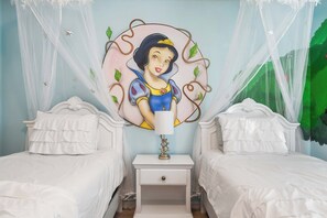 A bedroom with two beds, a nightstand, and a wall mural.