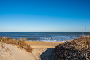 A beach with sand dunes and a clear blue sky.