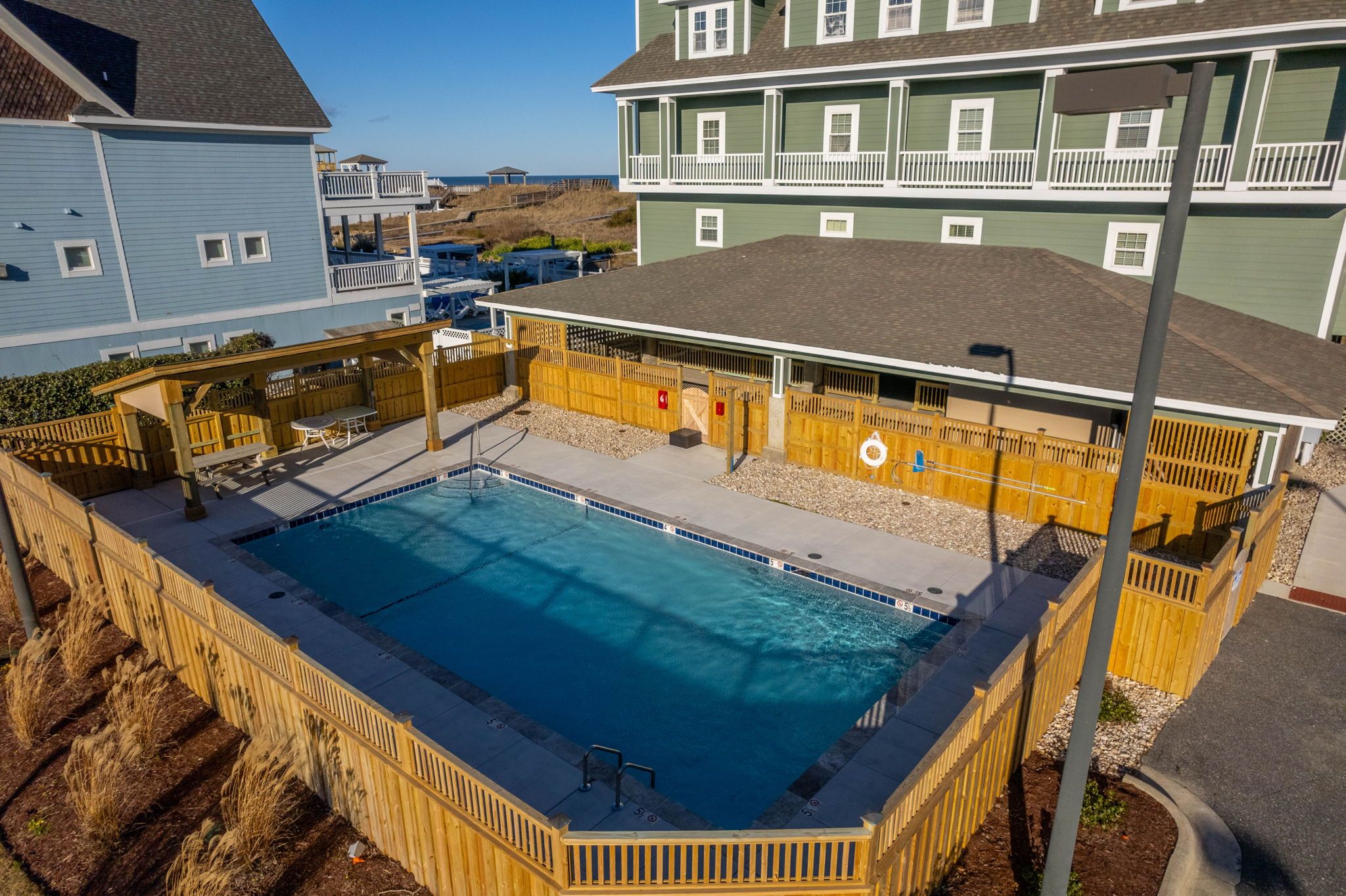 Ein rechteckiger Pool mit Holzterrasse und Rettungsschwimmerstation.