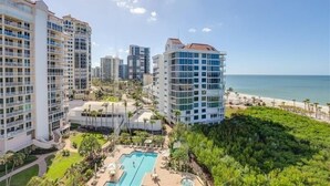 Un hotel de gran altura con varios balcones, una zona de piscina y vistas a la playa.