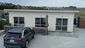 Uma casa moderna de dois andares com um carro estacionado na frente.