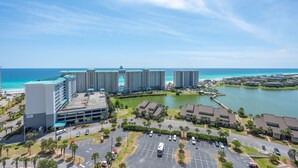 Een hotelcomplex met meerdere gebouwen, een parkeerplaats en uitzicht op de oceaan.