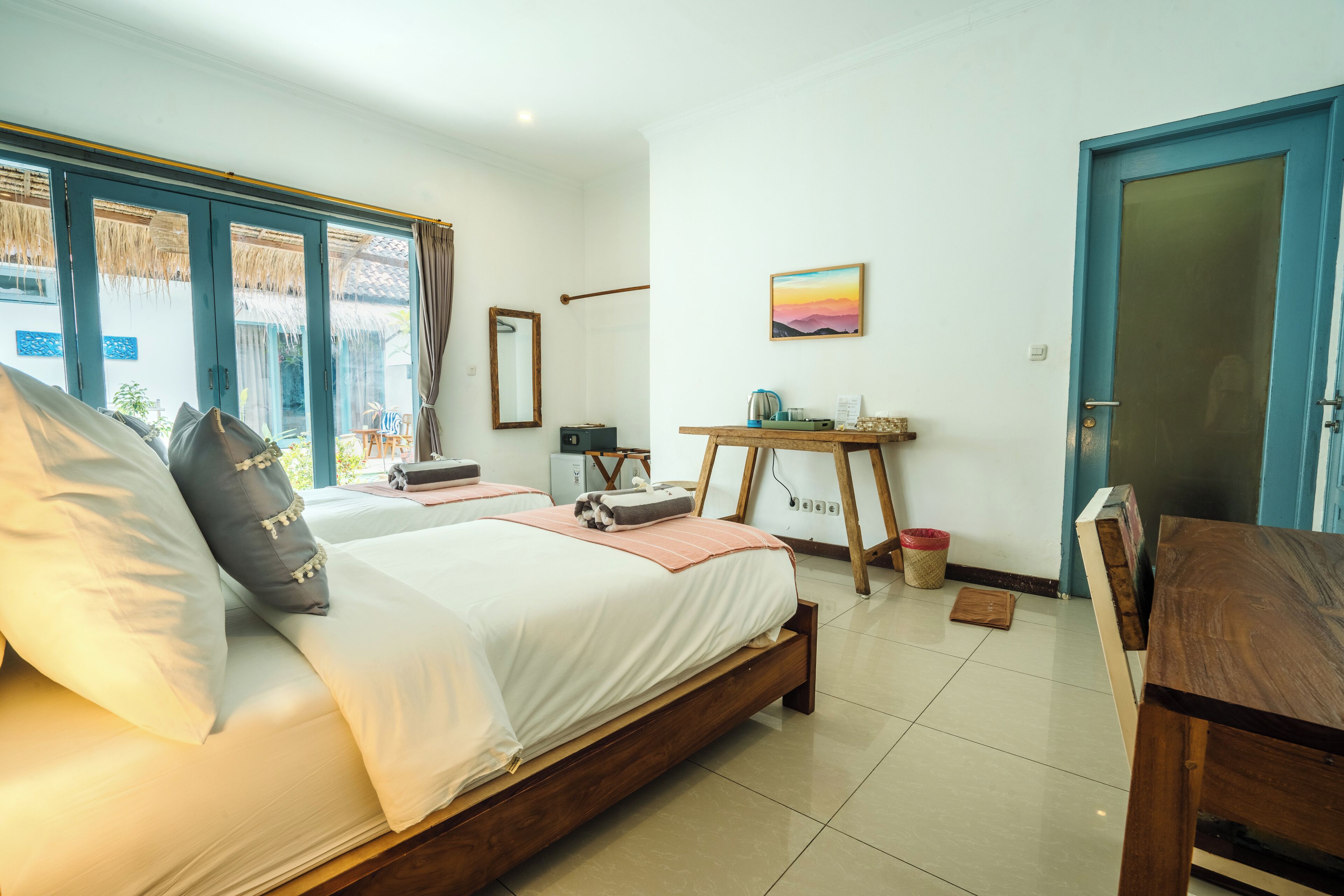 Een slaapkamer met een groot bed, een bureau en uitzicht door een raam.
