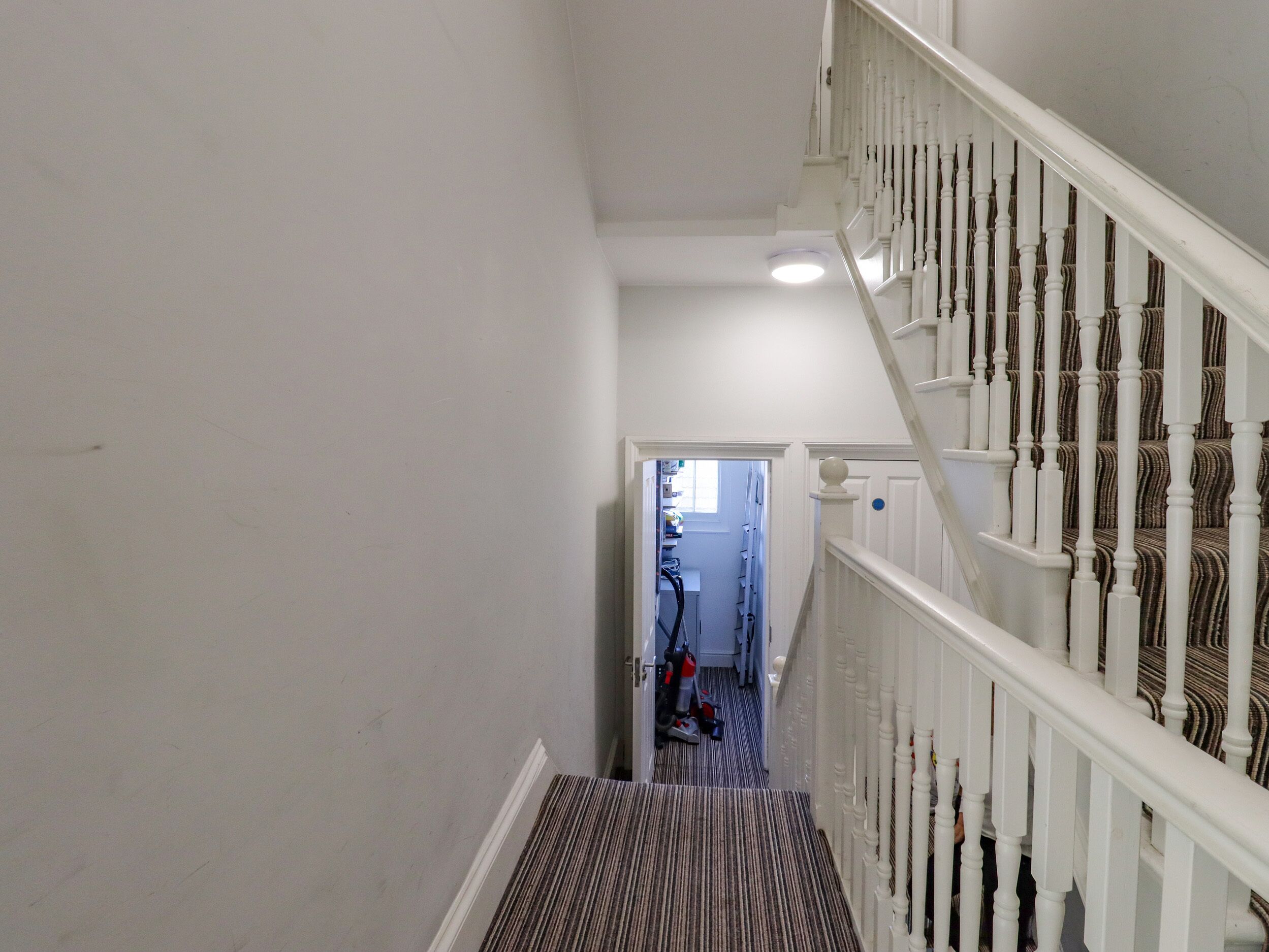 Un escalier avec des balustrades blanches menant à un palier.