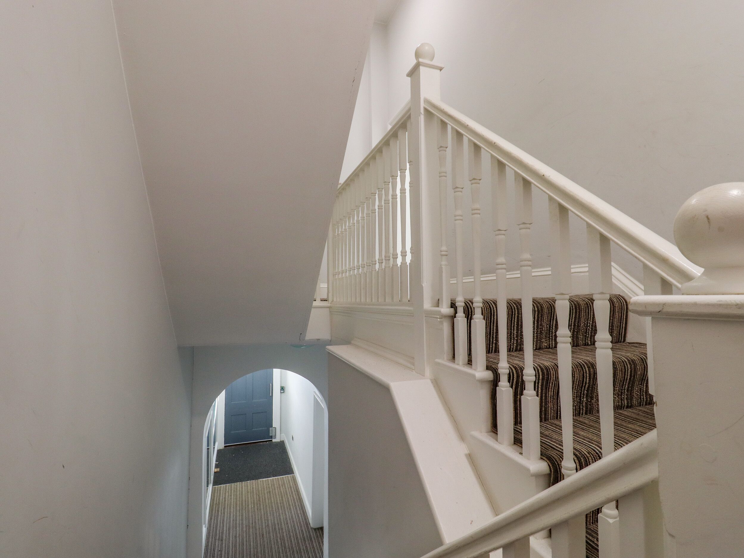 Eine Treppe mit weißen Balustraden und einem Teppich.