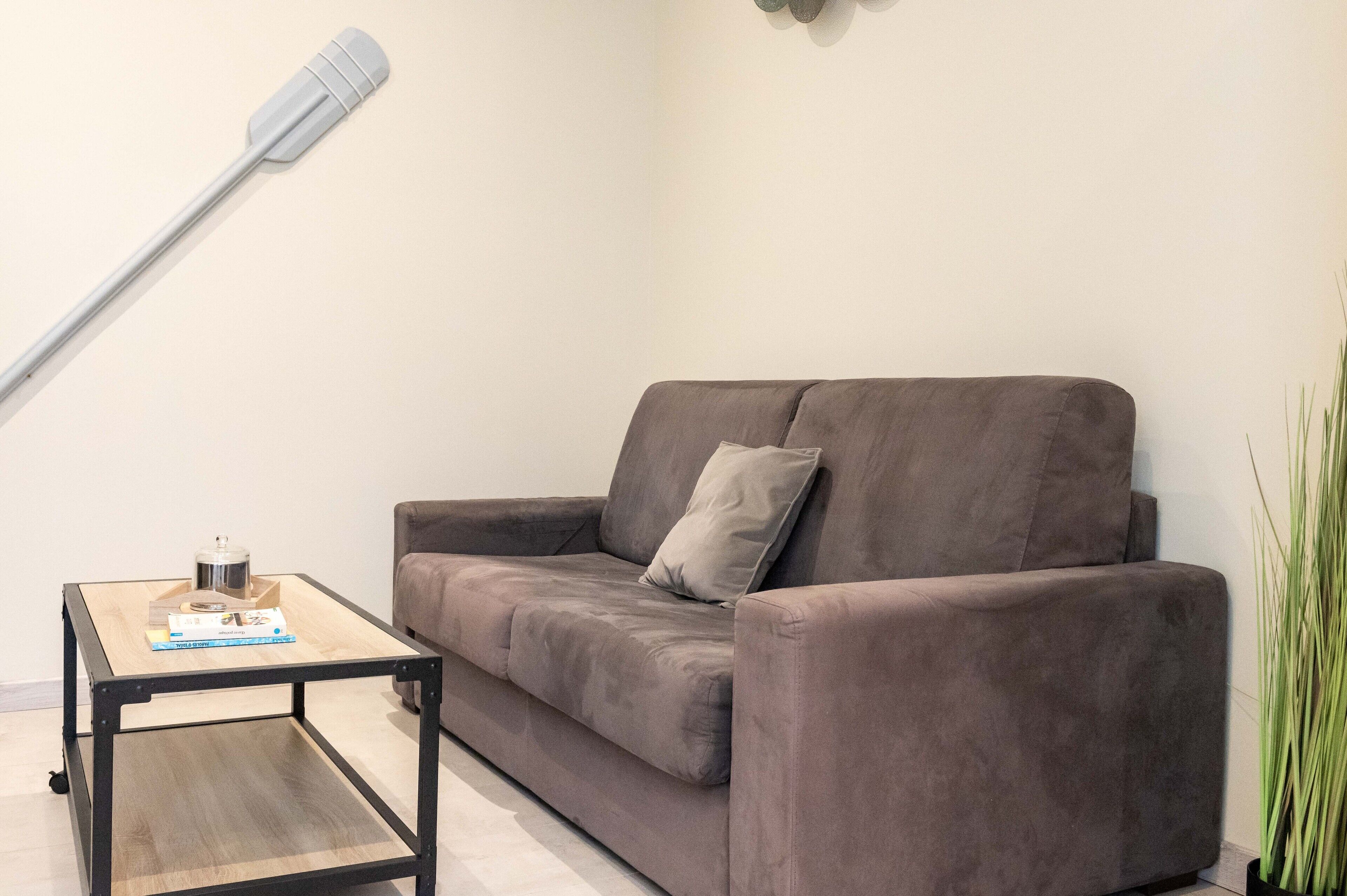 A living room with a sofa, a coffee table, and a floor lamp.