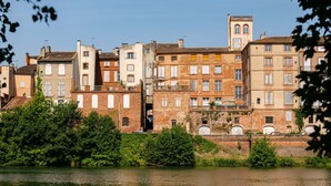 A row of historic buildings with a river in the foreground.
