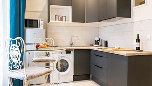 A compact kitchen with a washing machine, a microwave, and a coffee maker.