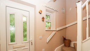 A staircase with beige carpeted steps, white walls, and a small window with a view of greenery. - 2 Bathsheba Terrace (Dorchester)