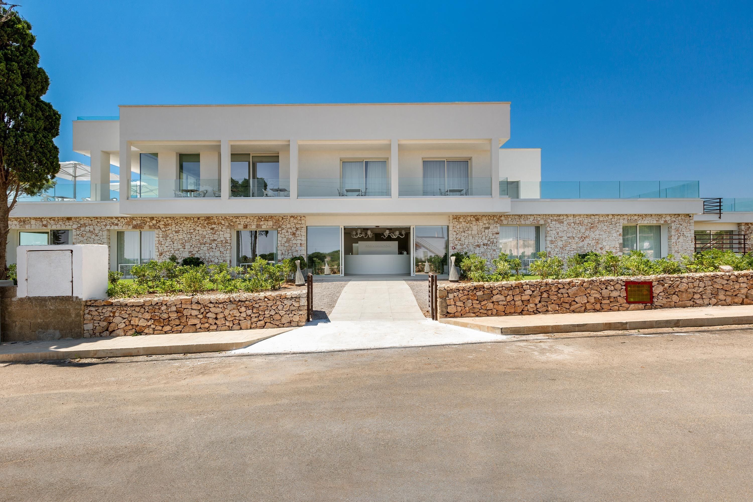 Un bâtiment moderne à deux étages, doté d’une façade en pierre, d’une entrée centrale et offrant une vue dégagée sur la rue.