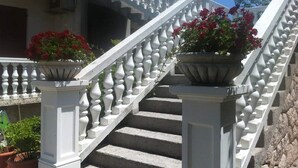 Una escalera de piedra con balaustradas blancas que conduce a un edificio.