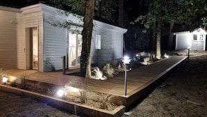 A modern, single-story cabin with a wooden deck and a small garden area. - Very bright Scandinavian chalet located 3 min. from the lake and 10 min. of the (BISCARROSSE)