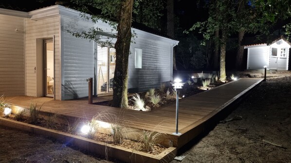 A modern, single-story cabin with a wooden deck and a small garden area. - Very bright Scandinavian chalet located 3 min. from the lake and 10 min. of the (BISCARROSSE)