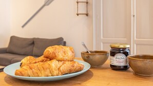 Une assiette de croissants sur une table, avec un pot de miel et un bol de miel.