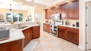 A spacious kitchen with wooden cabinets, a central island, and modern appliances.