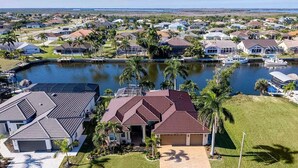 A residential area with houses, a body of water, and boats.