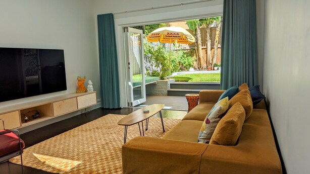 A modern living room with a sofa, TV, and a small table.