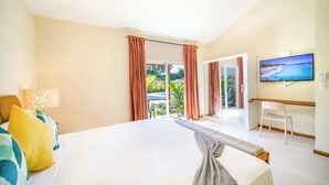 Een hotelkamer met een groot bed, een bureau, een televisie en uitzicht op de omgeving.