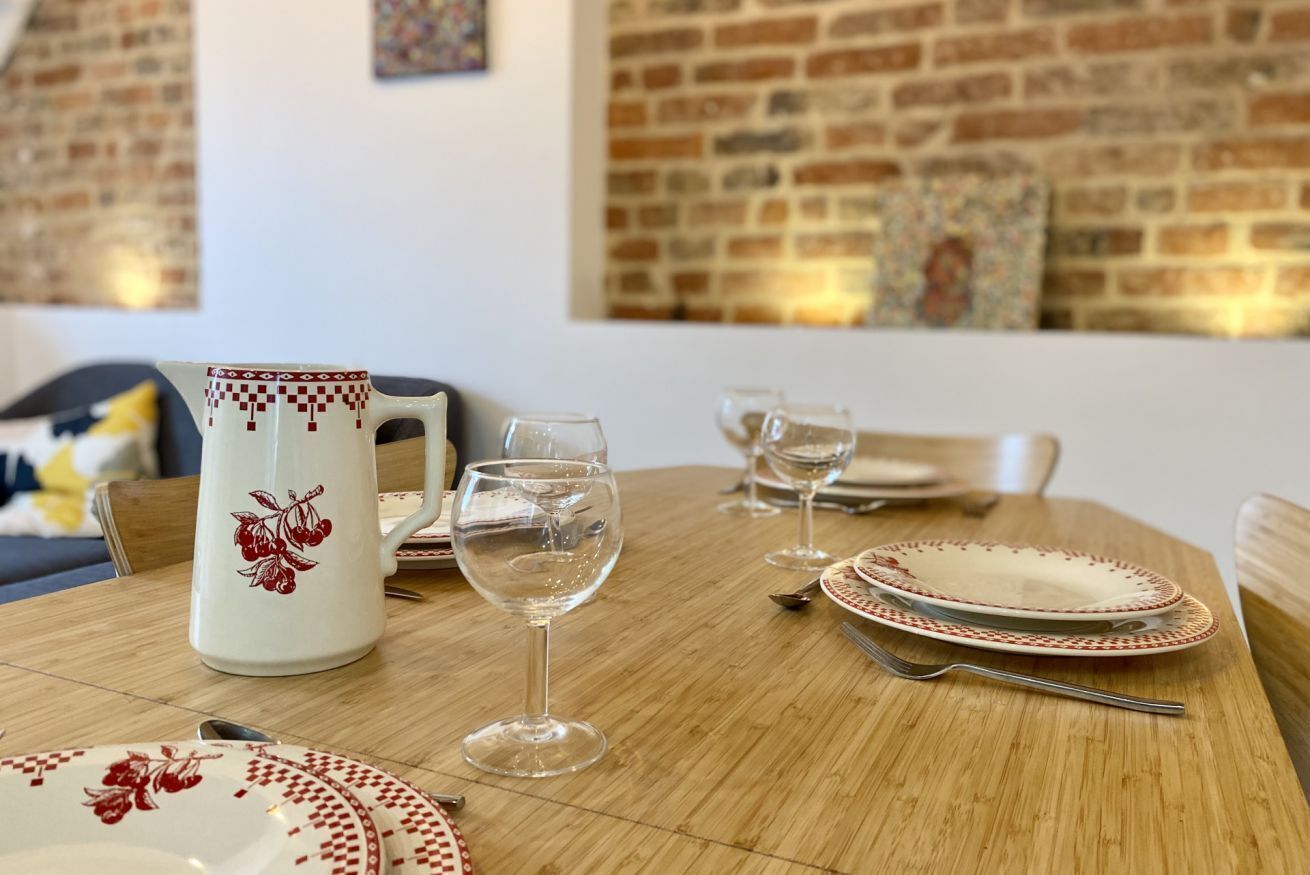Un tavolo da pranzo con piatti, bicchieri e una brocca.