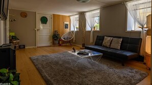 Una sala de estar con un sofá, una mesa de centro, una silla y un dardo.