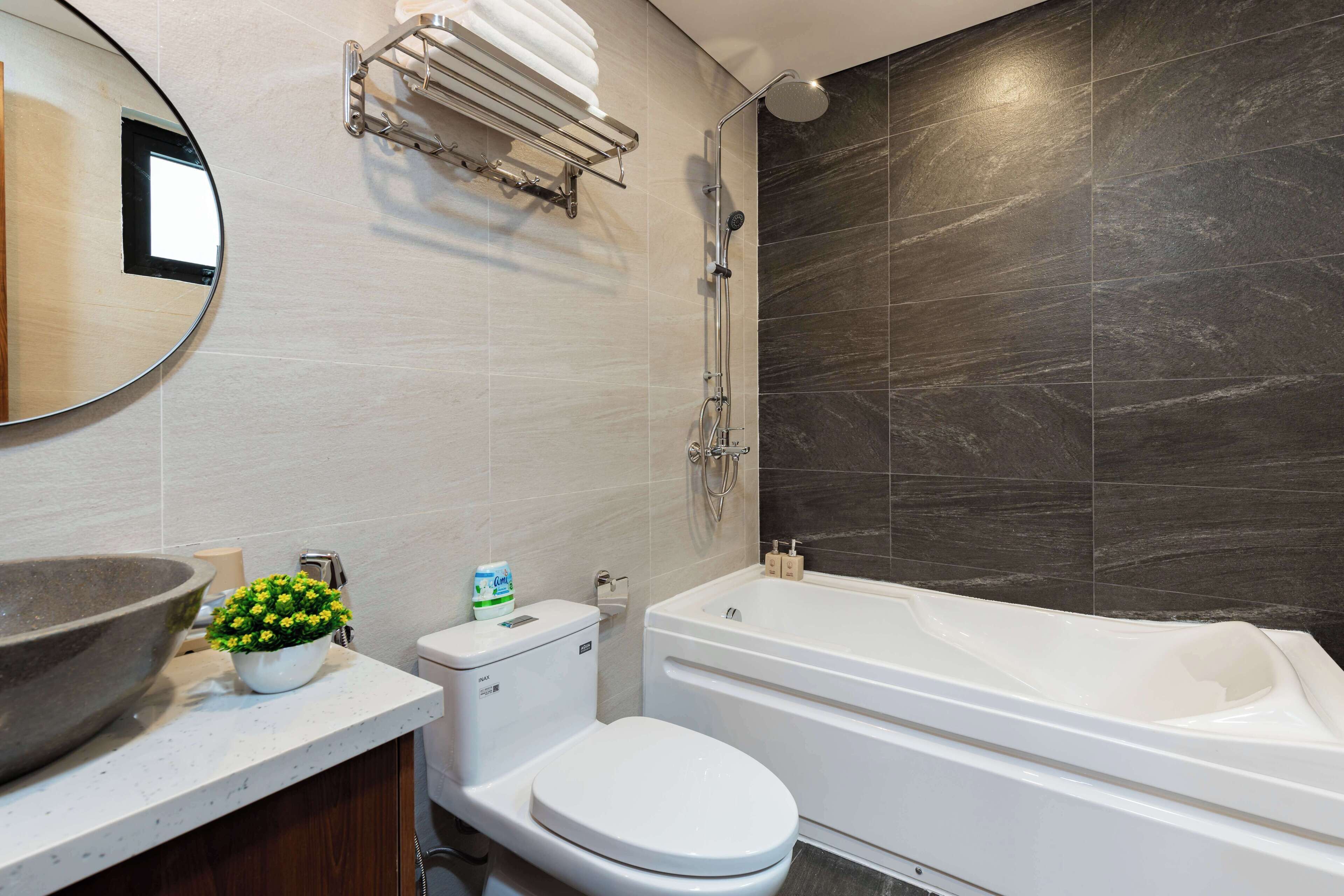 A modern bathroom with a large sink, toilet, and bathtub.